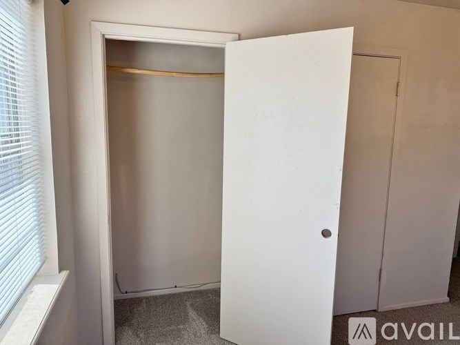 A white door is open to a room with a carpeted floor.