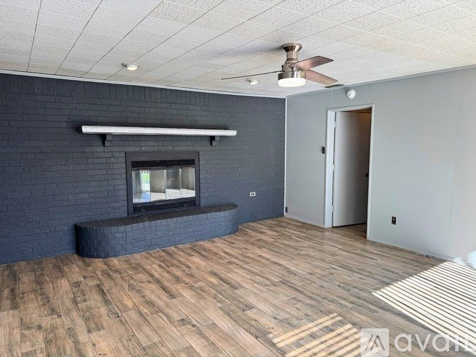 A room with a fireplace and a ceiling fan.