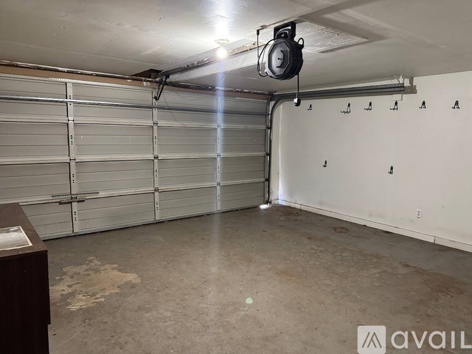 A garage with a white wall and a closed white door.