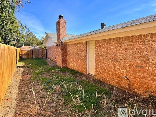 A backyard with a brick wall and a wooden fence.