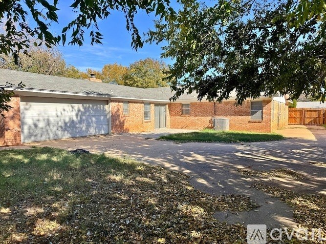 A house with a driveway and a tree in front.
