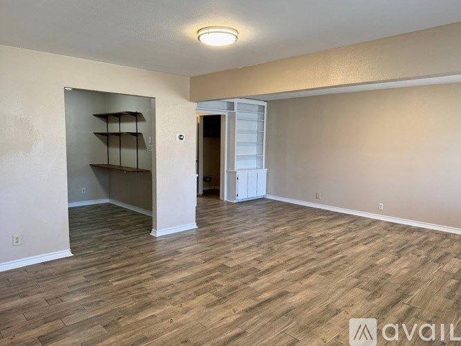 A room with wooden flooring and a white door.