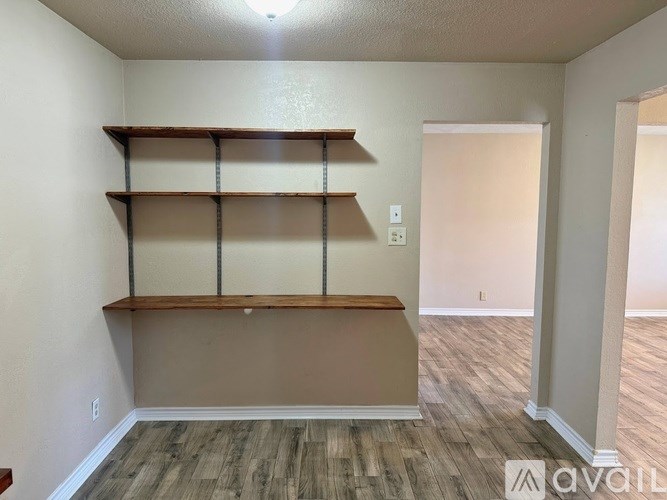 A room with wooden shelves and a light brown floor.