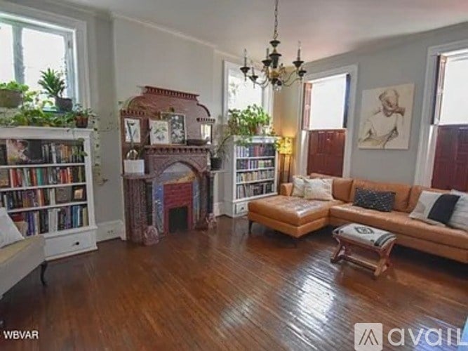 A living room with a fireplace, bookshelves, and a couch.