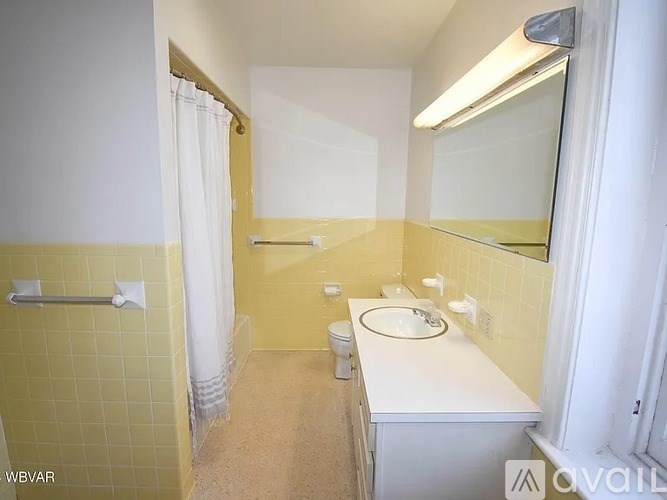 A bathroom with yellow walls and a white counter.