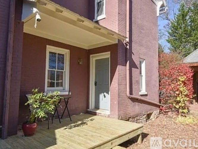 A red brick house with a white door and a small porch.