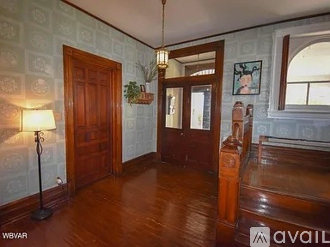 A room with wooden floors and a wallpapered wall.