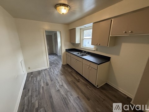 A kitchen with wooden floors and white walls.