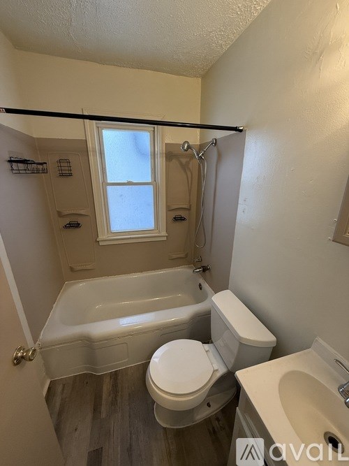 A bathroom with a toilet, sink, and bathtub.