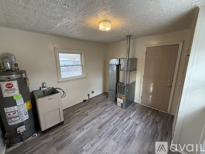 A room with a window, a sink, and a furnace.