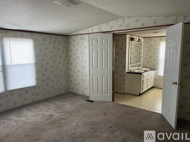 A room with a carpeted floor and a wallpapered wall with a pattern of stars.