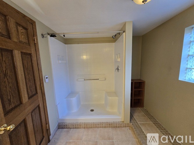A bathroom with a tub and a wooden door.