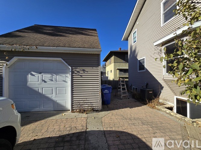 A white car is parked in front of a garage.