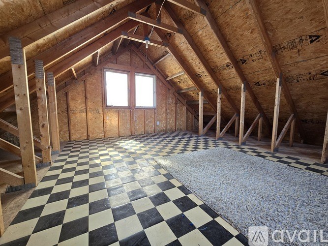 A room under construction with wooden beams and a checkered floor.
