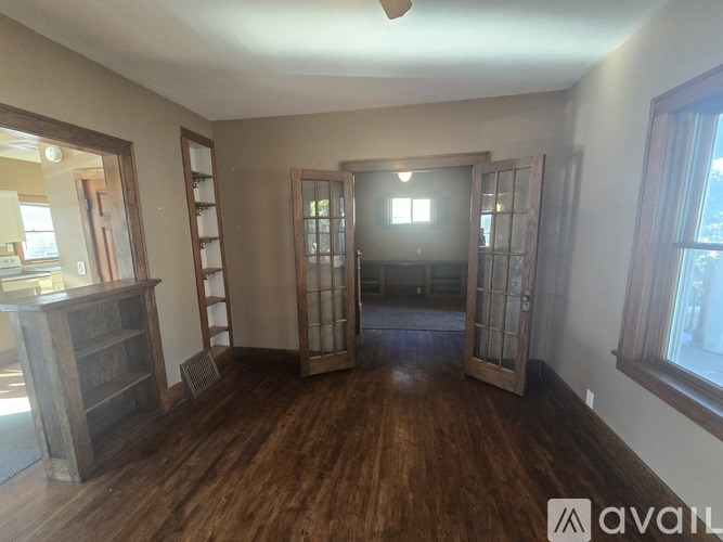 A room with wooden floors and a large open doorway.
