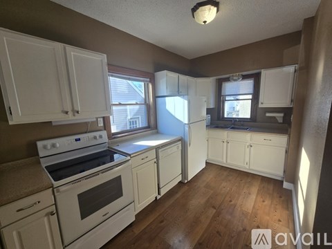A kitchen with white cabinets and appliances.