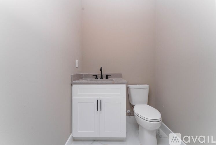 A white toilet sits next to a sink in a small bathroom.