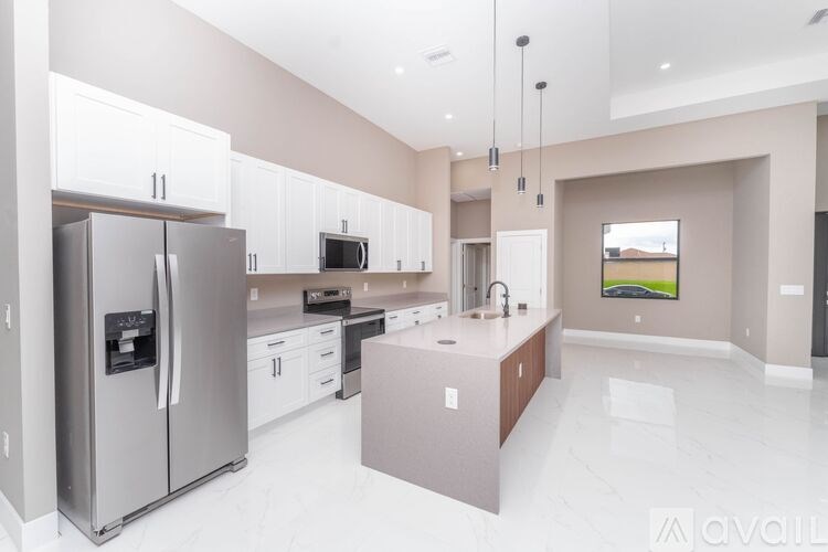 A modern kitchen with a refrigerator, microwave, and oven.