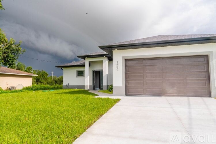 A house with a garage door and a driveway in front of it.