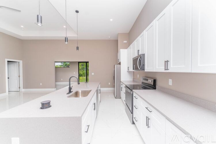 A modern kitchen with white countertops and cabinets.