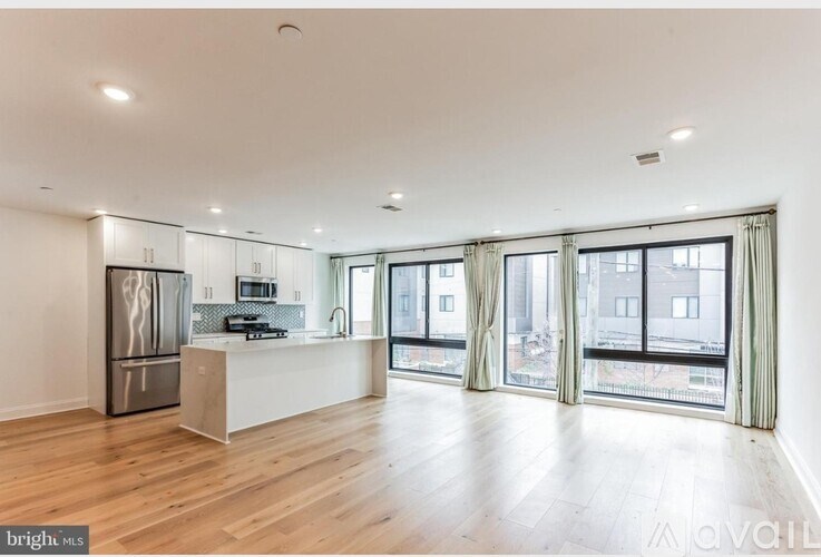 A spacious kitchen with wooden floors and a large island.