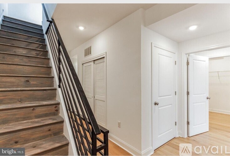 A staircase with wooden steps and a black railing.