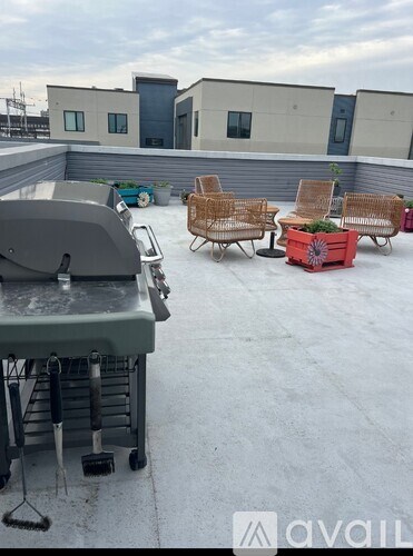 A patio with a grill and chairs.