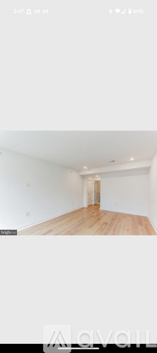 A room with wooden flooring and white walls.