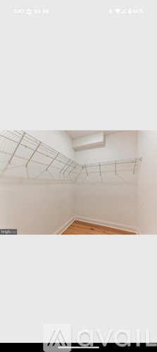 A white wall with a wooden floor.