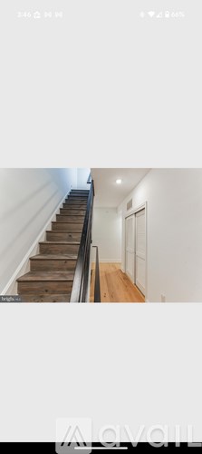 A wooden staircase leads up to a white door.