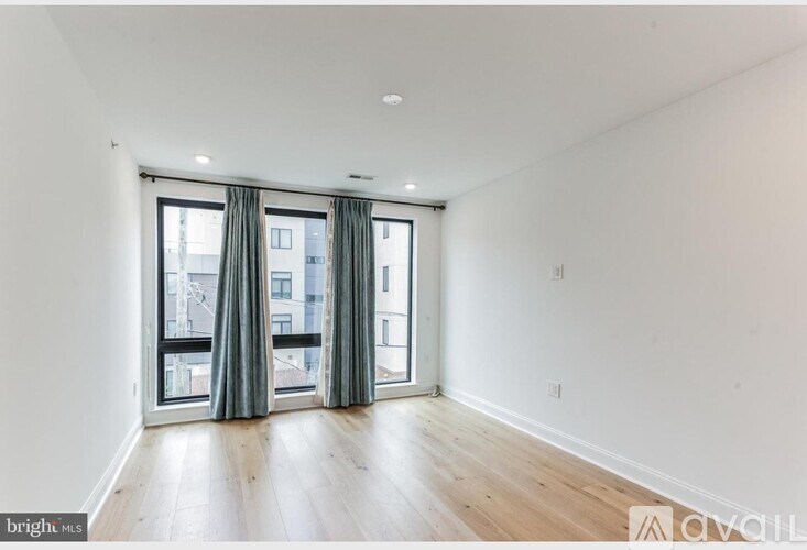 A bright, empty room with a sliding glass door leading to a balcony.