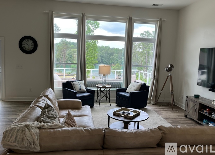 A living room with a large couch and a clock on the wall.