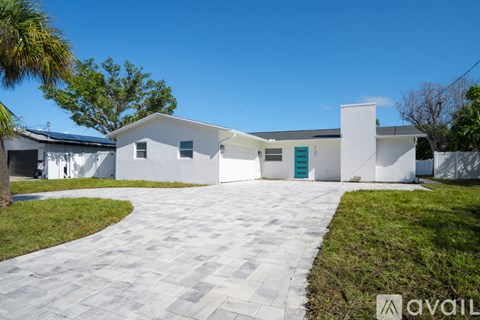 A white house with a grey tiled walkway in front.