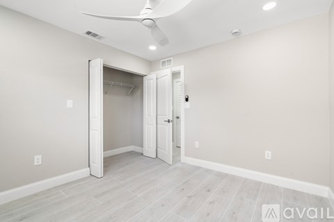 A room with a ceiling fan and a white door.