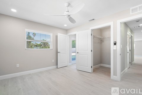 A room with a ceiling fan and a window with blinds.