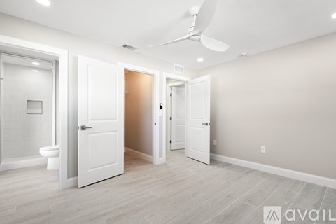 A room with a toilet, a fan, and a door.