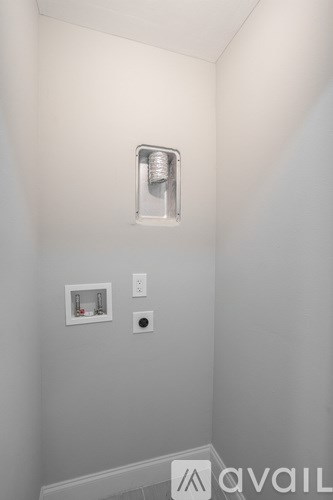 A white wall with a light switch and a socket.