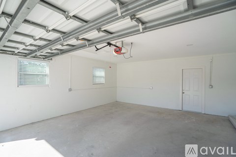 A room with a white ceiling and walls, a window with blinds, a door, and a fire extinguisher hanging from the ceiling.