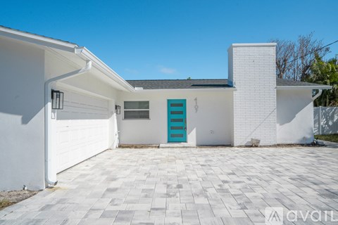 A white house with a blue door and a white garage door.