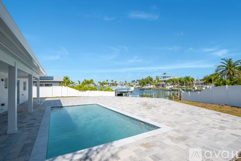 A swimming pool in a backyard with a white tiled floor.