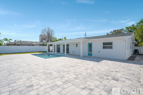 A white house with a pool in the backyard.