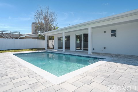 A white house with a pool in the backyard.