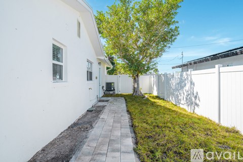 A white house with a tree in front of it.