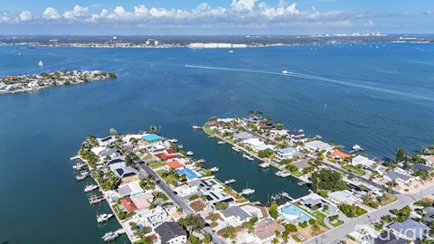 A small island with houses and boats in the water.