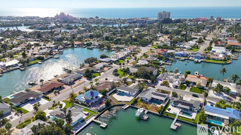 A bird's eye view of a coastal town with a large body of water and boats docked in the marina.