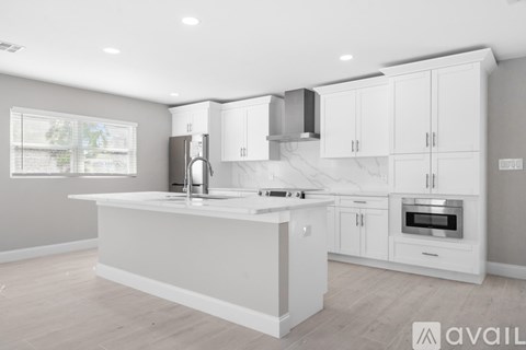 A modern kitchen with white cabinets and a central island.