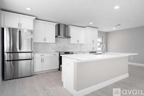 A modern kitchen with white cabinets and stainless steel appliances.