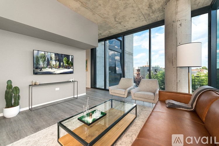 A modern living room with a glass coffee table and a large painting on the wall.