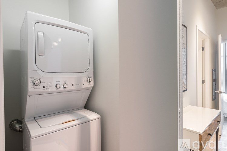 A white dryer is sitting in a room with a white wall.