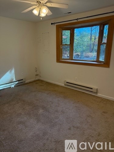 A room with a window and a ceiling fan.